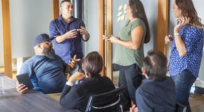 Successful Maori Pacific Islander business woman leading a team of entrepreneurs in a corporate business meeting.
