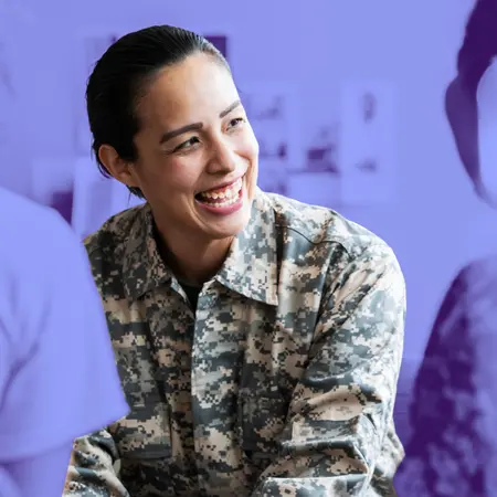 A female service member smiles at a colleague.