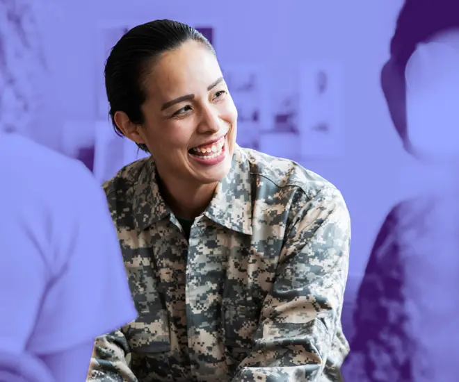 A female service member smiles at a colleague.