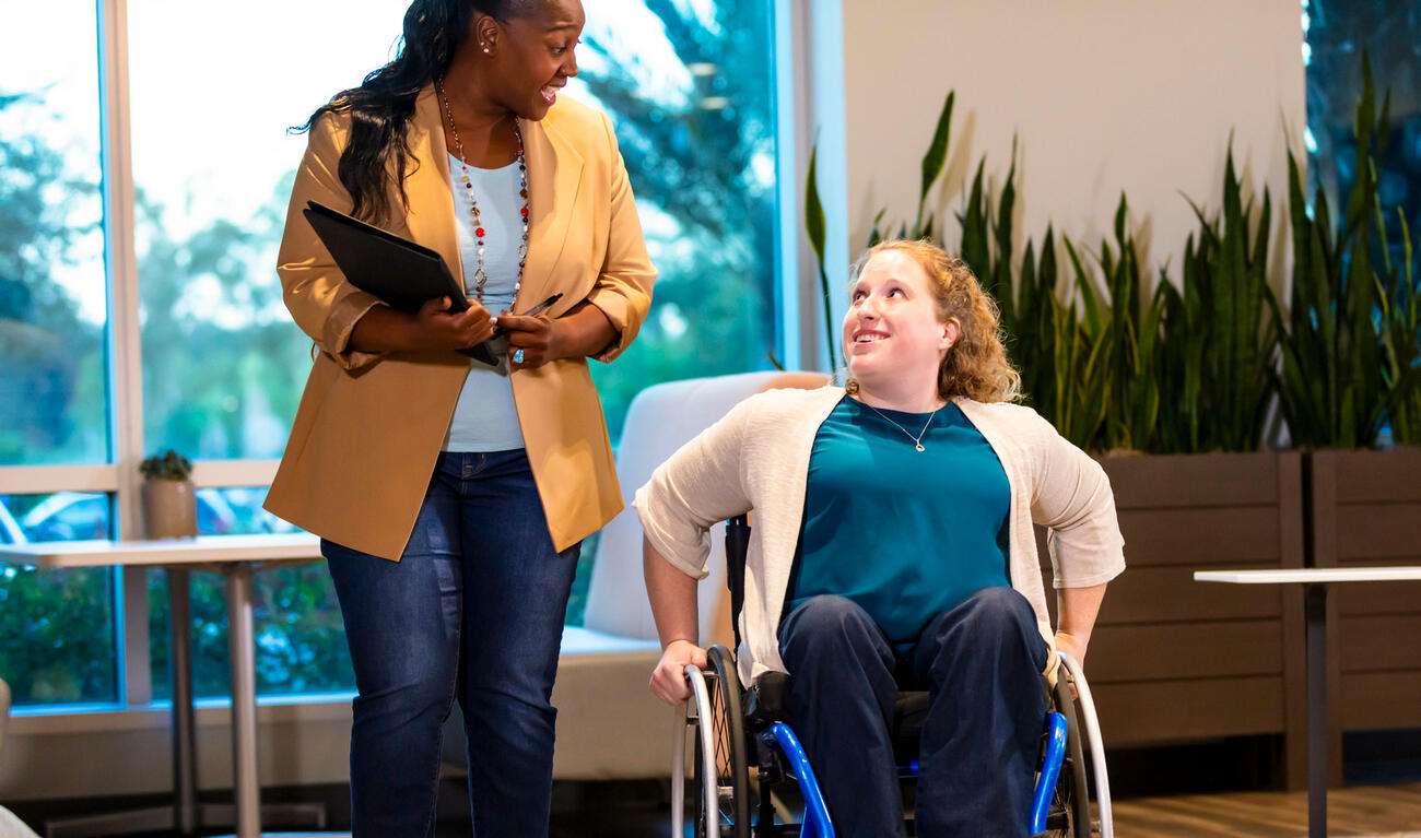 Two women converse as they move through a building