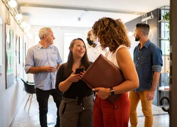 Coworkers converse with each other as they leave a meeting