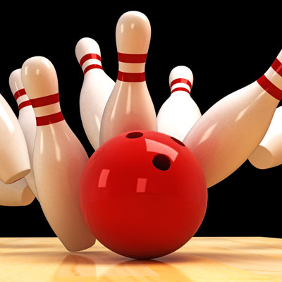 This photo of a bowling ball knocking down bowling pins represents the bowl-a-thon fundraising event idea that is popular with sports teams.