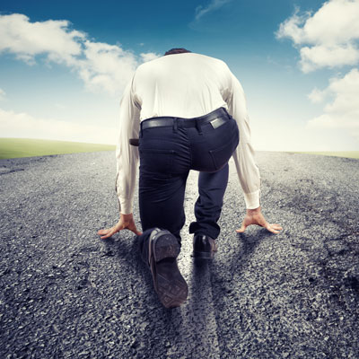 This photo of a person in business attire preparing to run a road race demonstrates the concept of the in-house competition fundraising event idea.