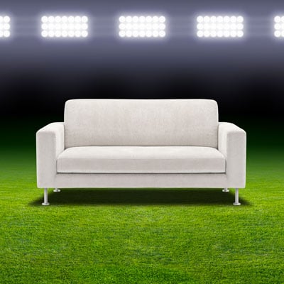 This photo of a couch under sports stadium lights represents a couch raffle, which is a creative and unique college fundraising event idea.