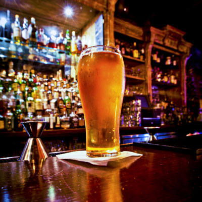 This photo of a glass of beer on a bar demonstrates the sorority- and fraternity-focused fundraising event idea of a pub crawl.