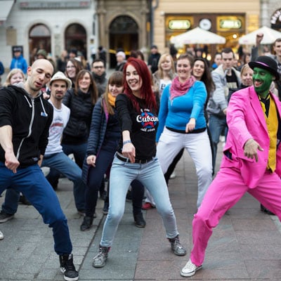 This photo of a large group of people dancing shows what the flash mob fundraising event idea looks like as it’s executed.