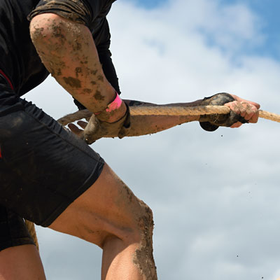 This close-up photo of someone completing an obstacle course demonstrates a fun fundraising event idea for sports teams.