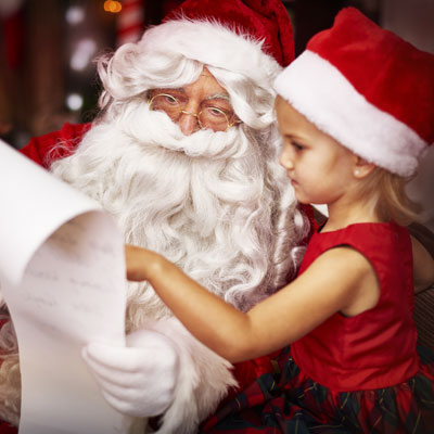 This photo of a child sitting on Santa’s lap demonstrates the popularity of the pictures with Santa fundraising event idea.