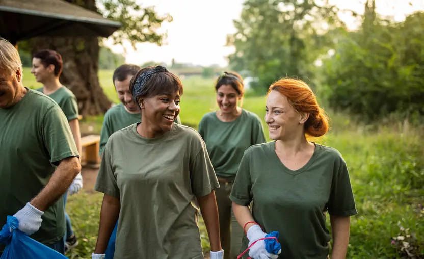 A group of volunteers outside cleaning up a park.