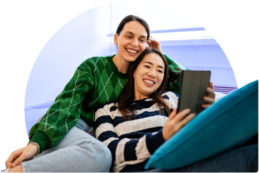 A couple relaxing and looking at a tablet