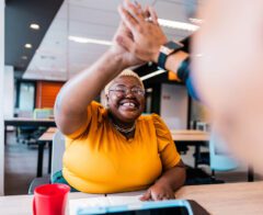 Coworkers celebrate a win with a high five