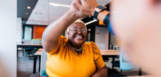 Coworkers celebrate a win with a high five