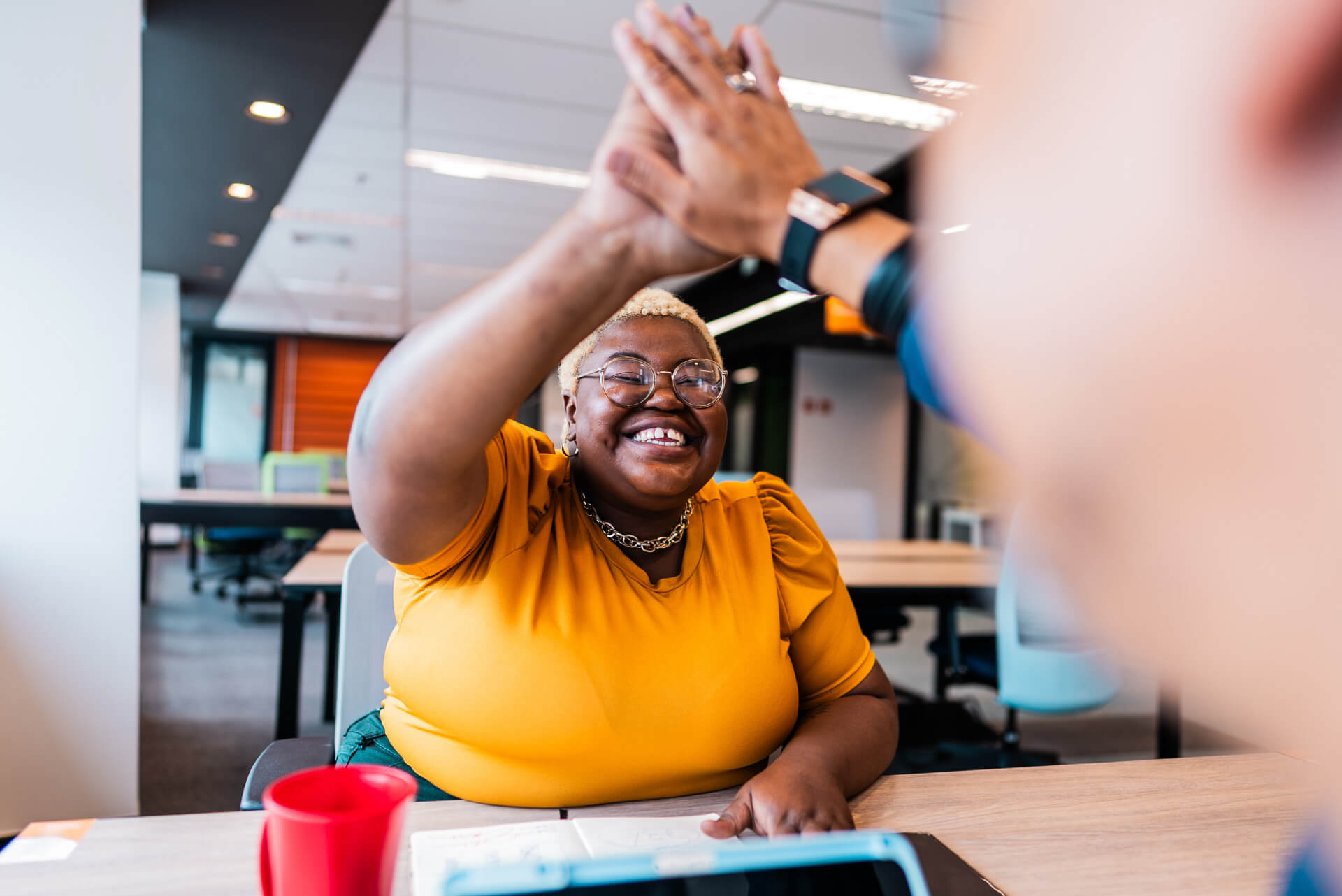 Coworkers celebrate a win with a high five