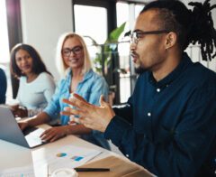 Coworkers meet and have a discussion in front of a laptop