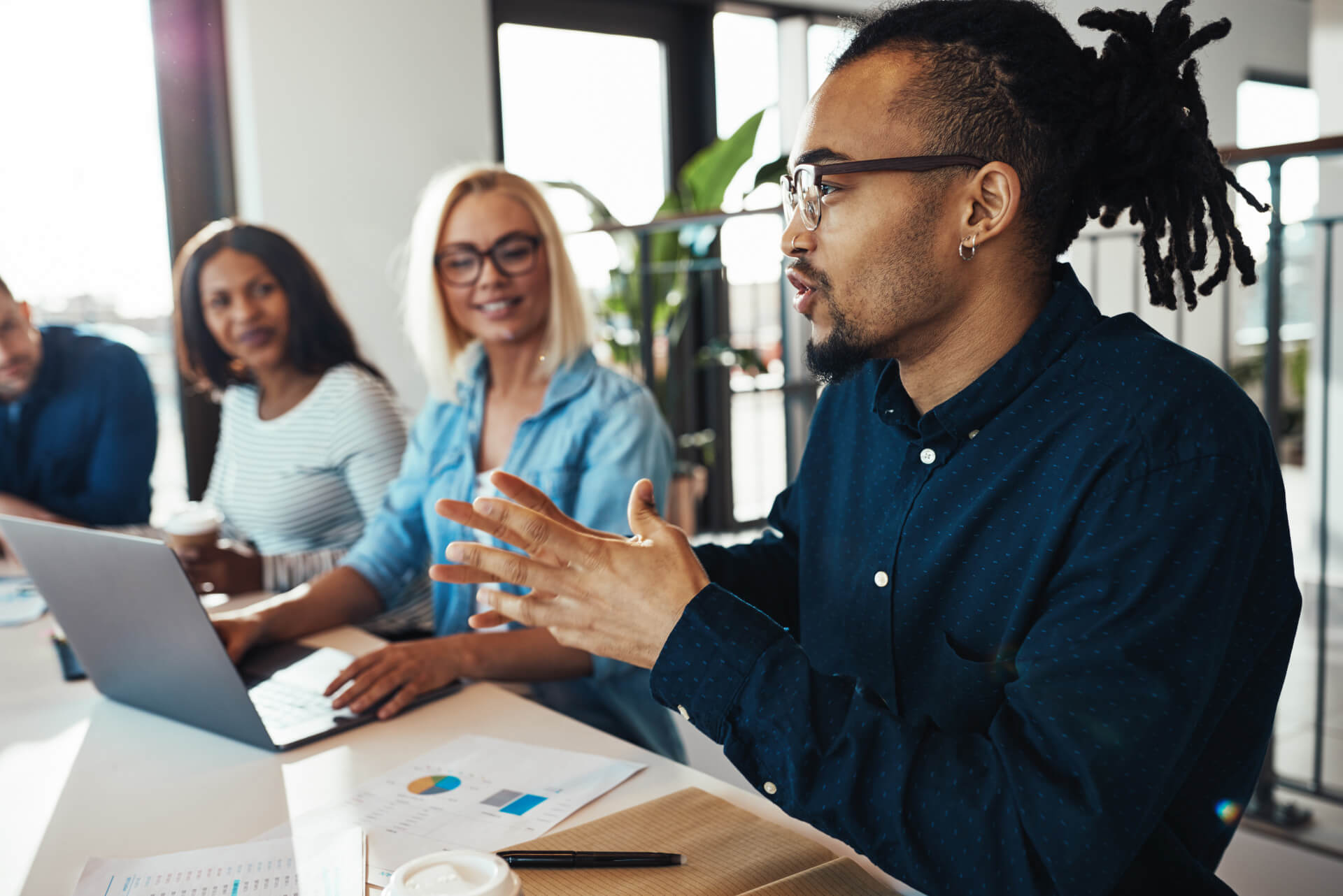 Coworkers meet and have a discussion in front of a laptop