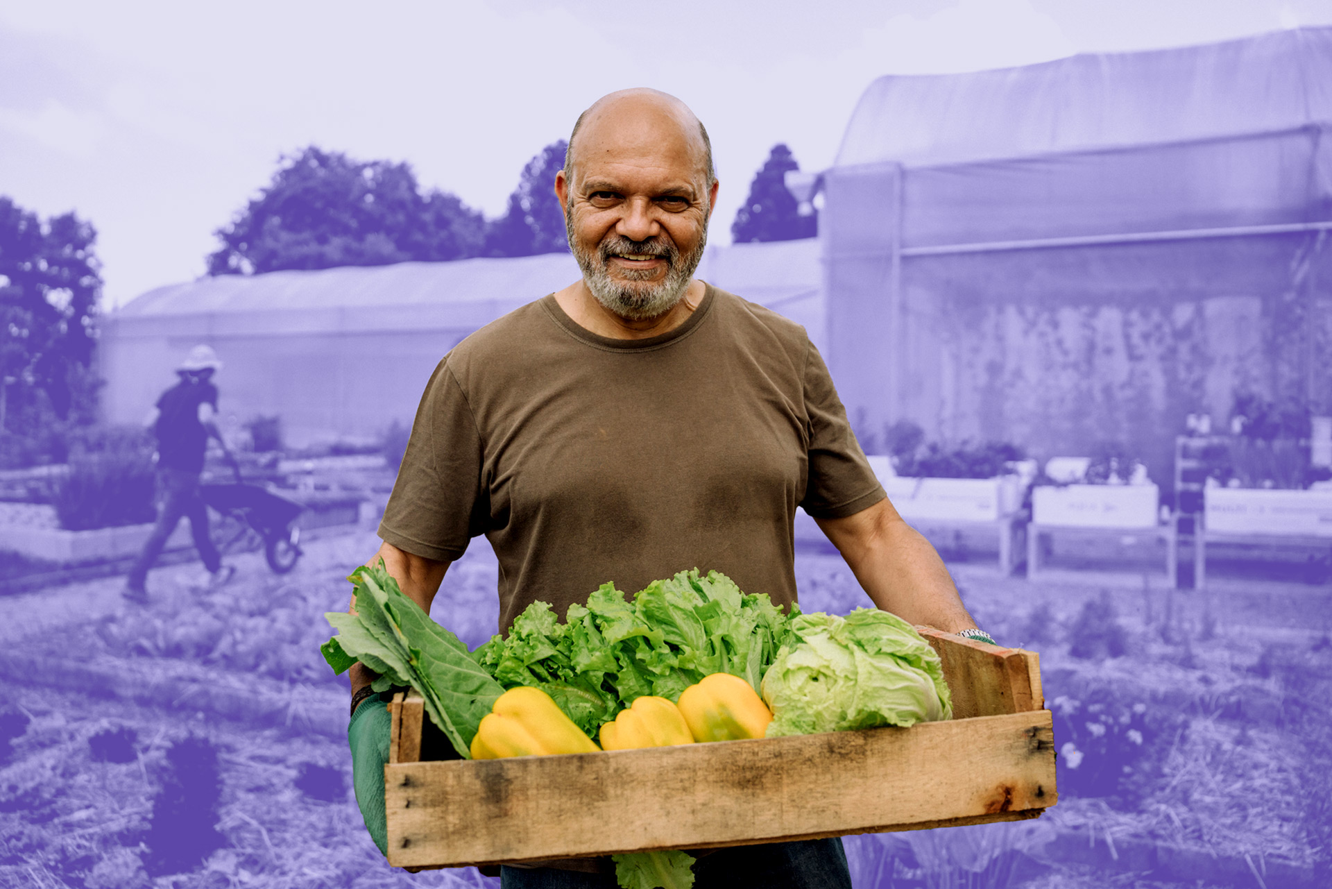 A man holds crops gathered from a farm.