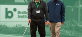 A Braille Institute employee helps guide a student on a walk.