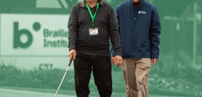 A Braille Institute employee helps guide a student on a walk.