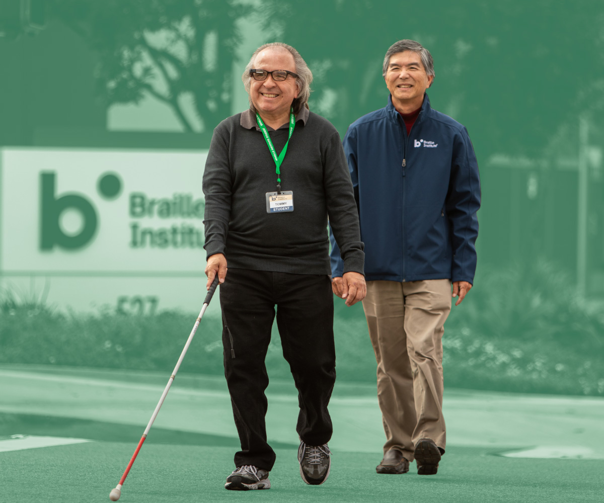 A Braille Institute employee helps guide a student on a walk.