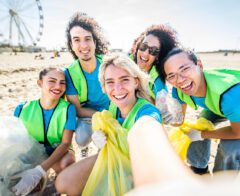 A group of employees works together to clean up a local shoreline.