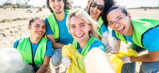 A group of employees works together to clean up a local shoreline.