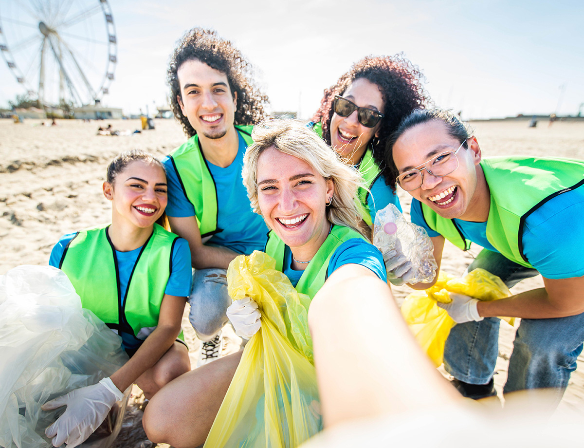 A group of employees works together to clean up a local shoreline.