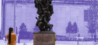 A visitor looks at a sculpture at the Auschwitz-Wasserman Holocaust Memorial Plaza