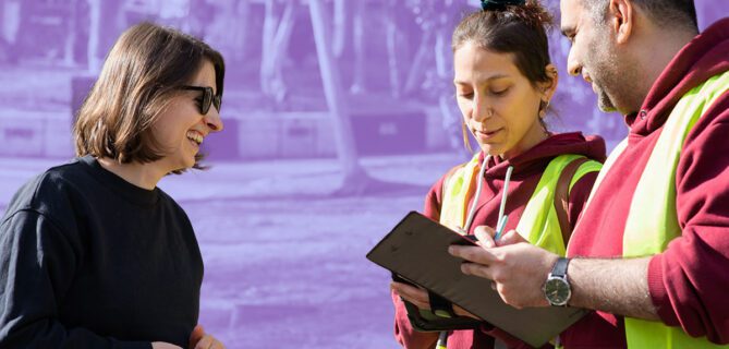 A photo of two volunteers processing a donor payment on a tablet.